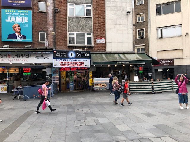 People walking in front of a building with a sign that says jamie