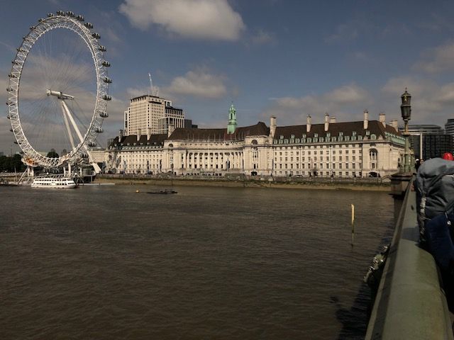 A large ferris wheel is in the middle of a body of water