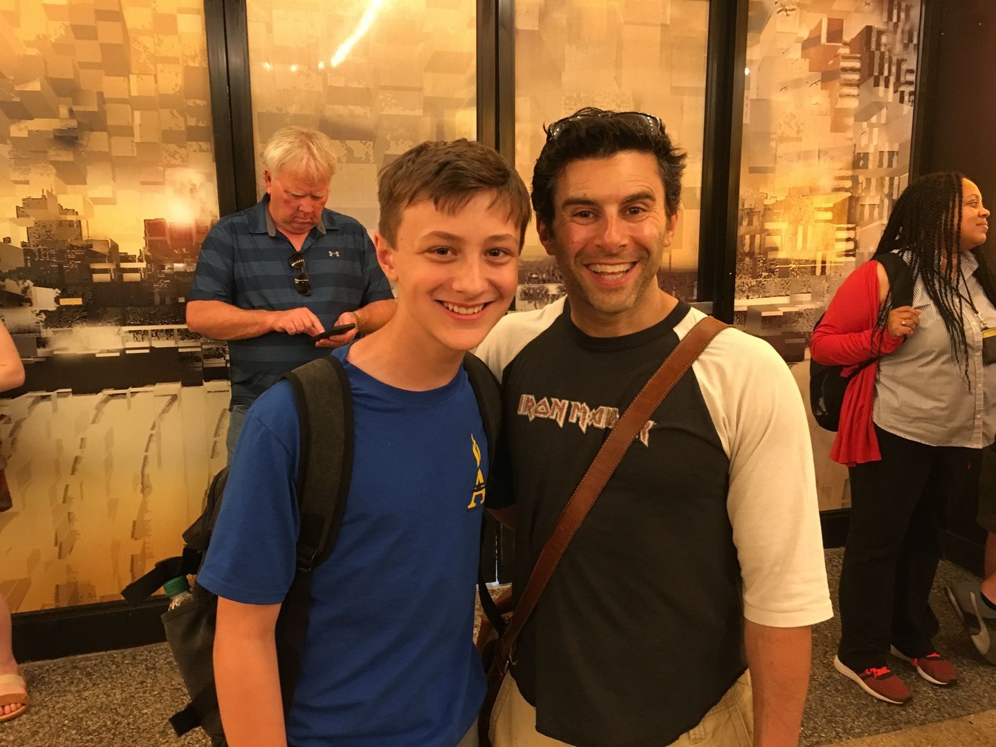A man and a boy are posing for a picture while standing next to each other.