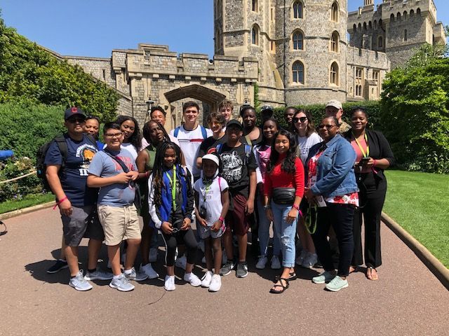 A group of people are posing for a picture in front of a castle.
