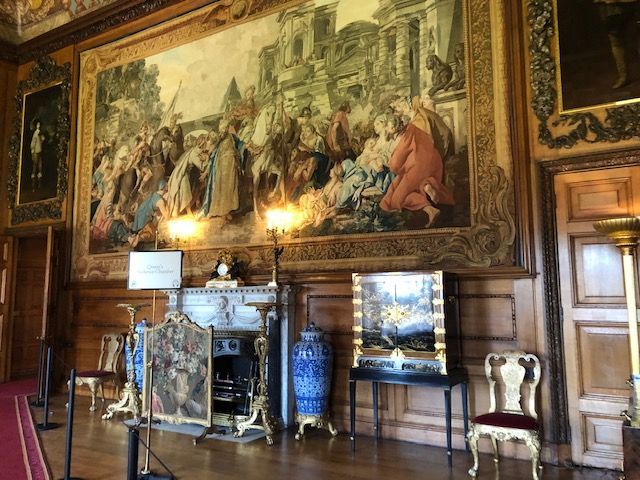 A room with a large painting on the wall and a fireplace.