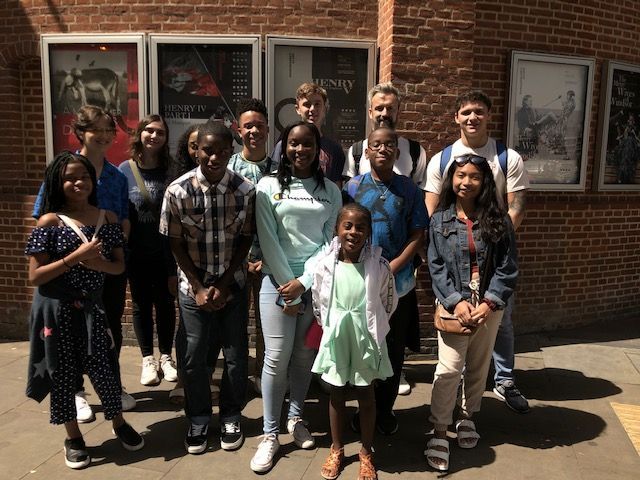 A group of people are posing for a picture in front of a brick building.