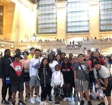 A group of people are posing for a picture in a large building.