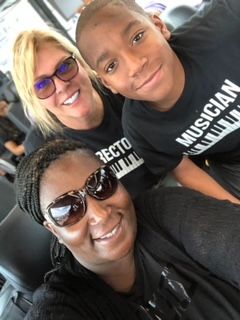A woman and a boy are posing for a picture while wearing musician shirts.