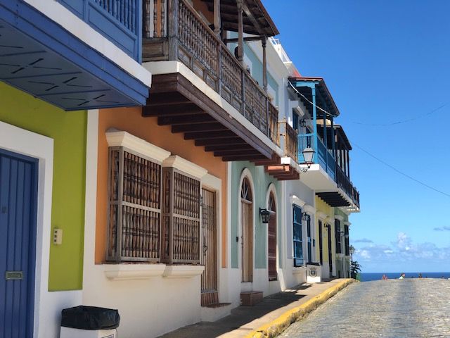 A row of colorful buildings on a cobblestone street
