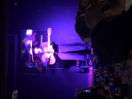 A person is taking a picture of a guitar on a stage.
