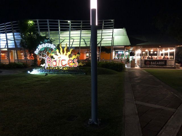 A sign in front of a building that says raices