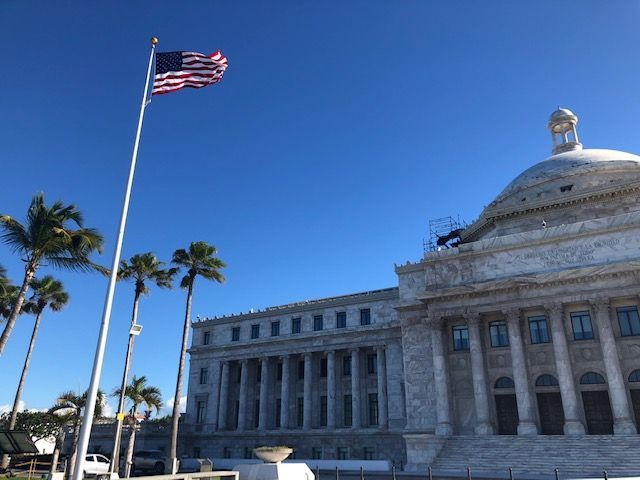 An american flag is flying in front of a large building