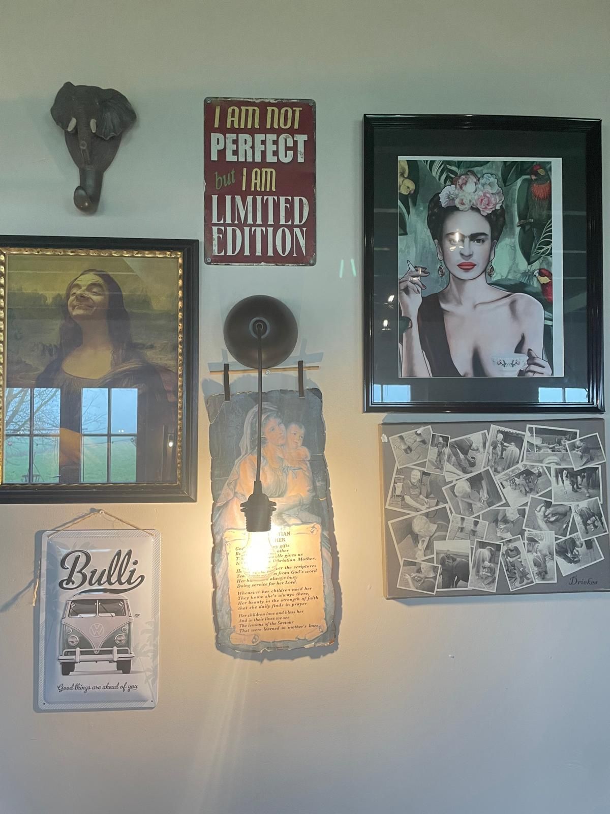 Wanddecoratie: print van Frida Kahlo, olifantenkop, VW-busje-logo en andere ingelijste kunstwerken.