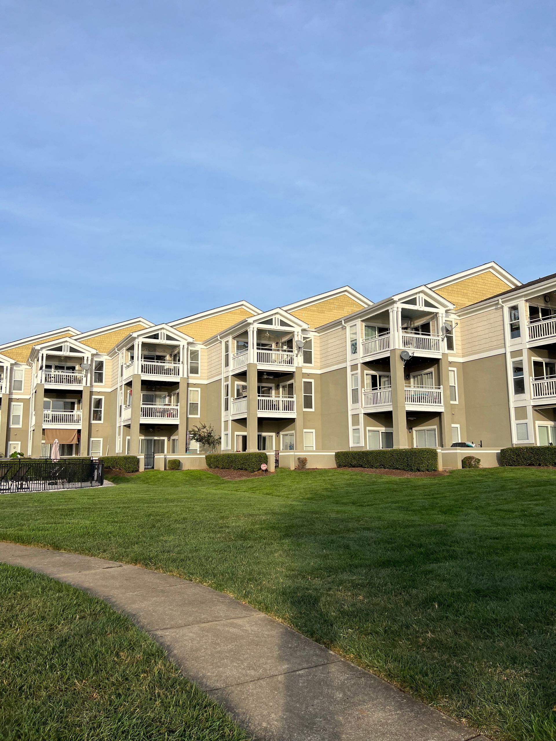 A large apartment building with a path leading to it.