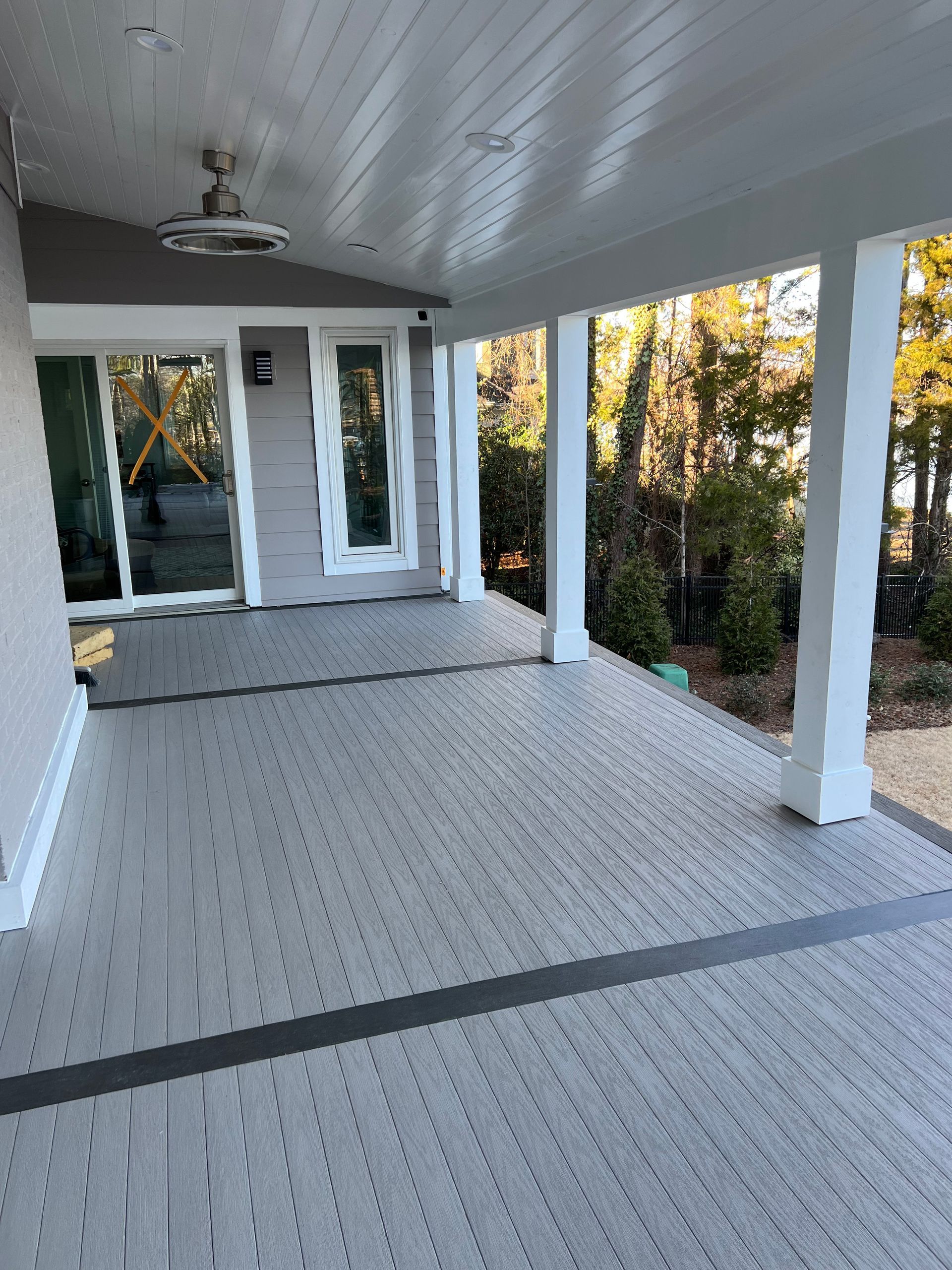 A porch with a ceiling fan and a sliding glass door