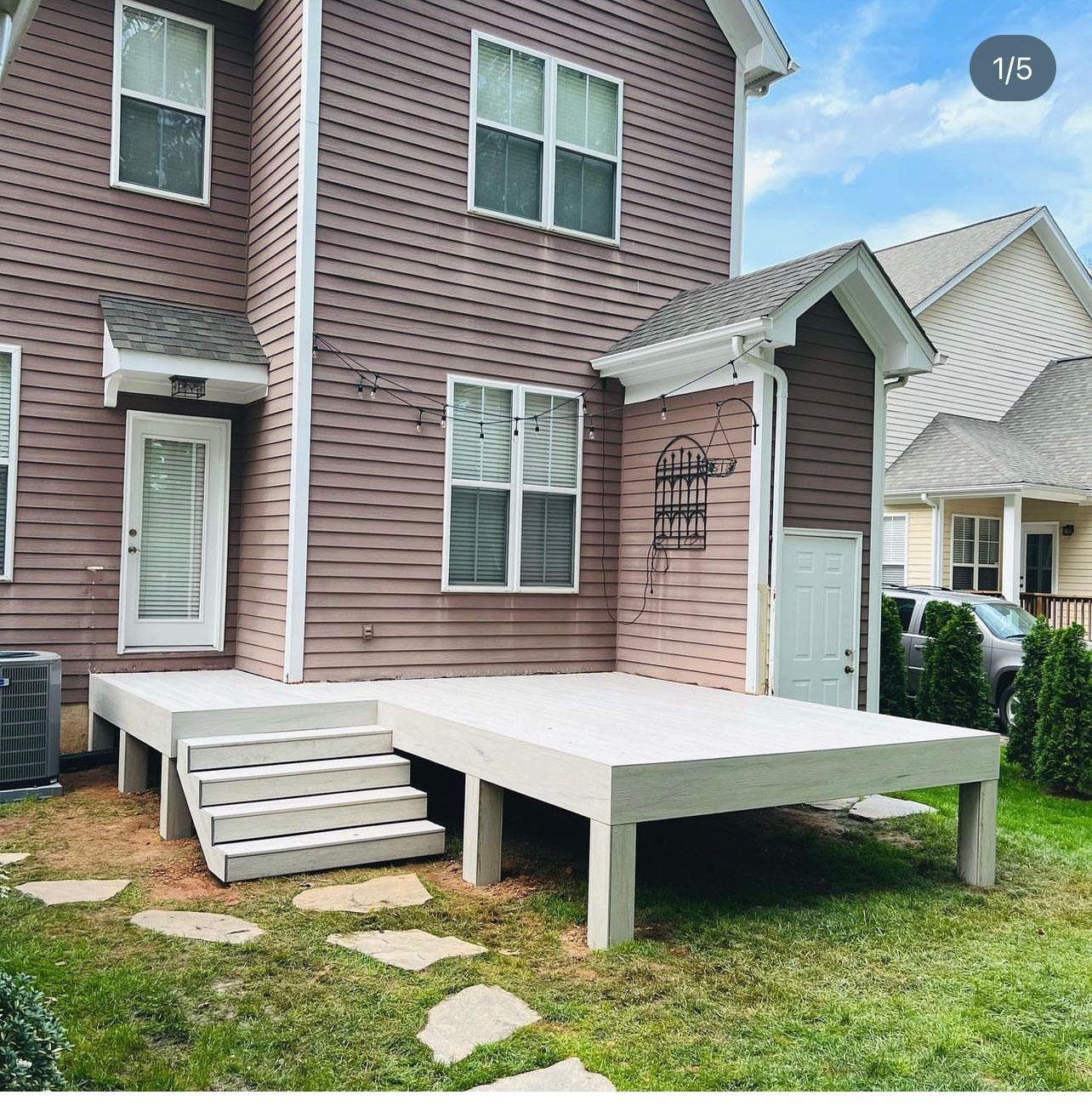 A house with a deck and stairs in front of it