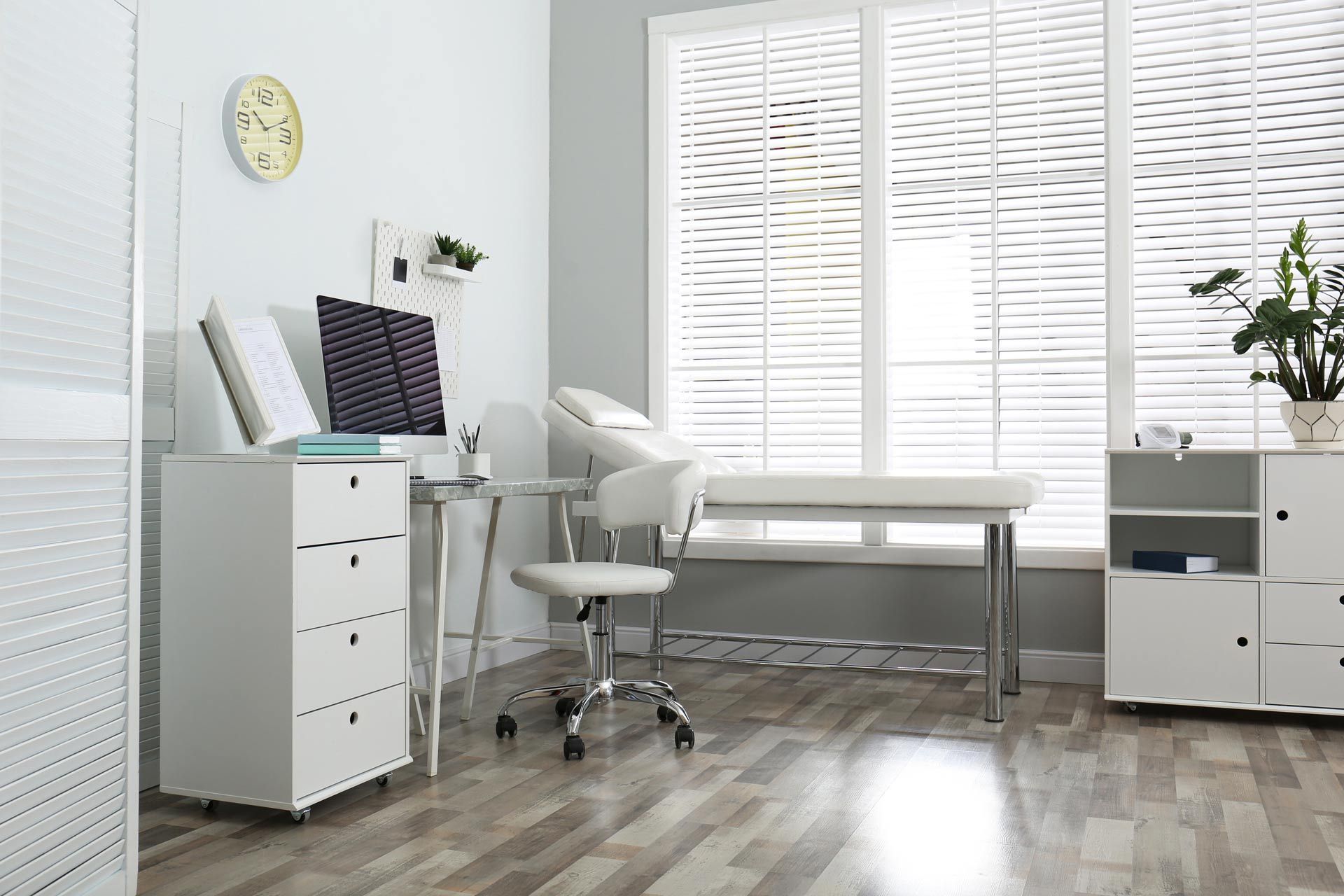 Modern white home office with desk, chair, filing cabinets, and large window blinds