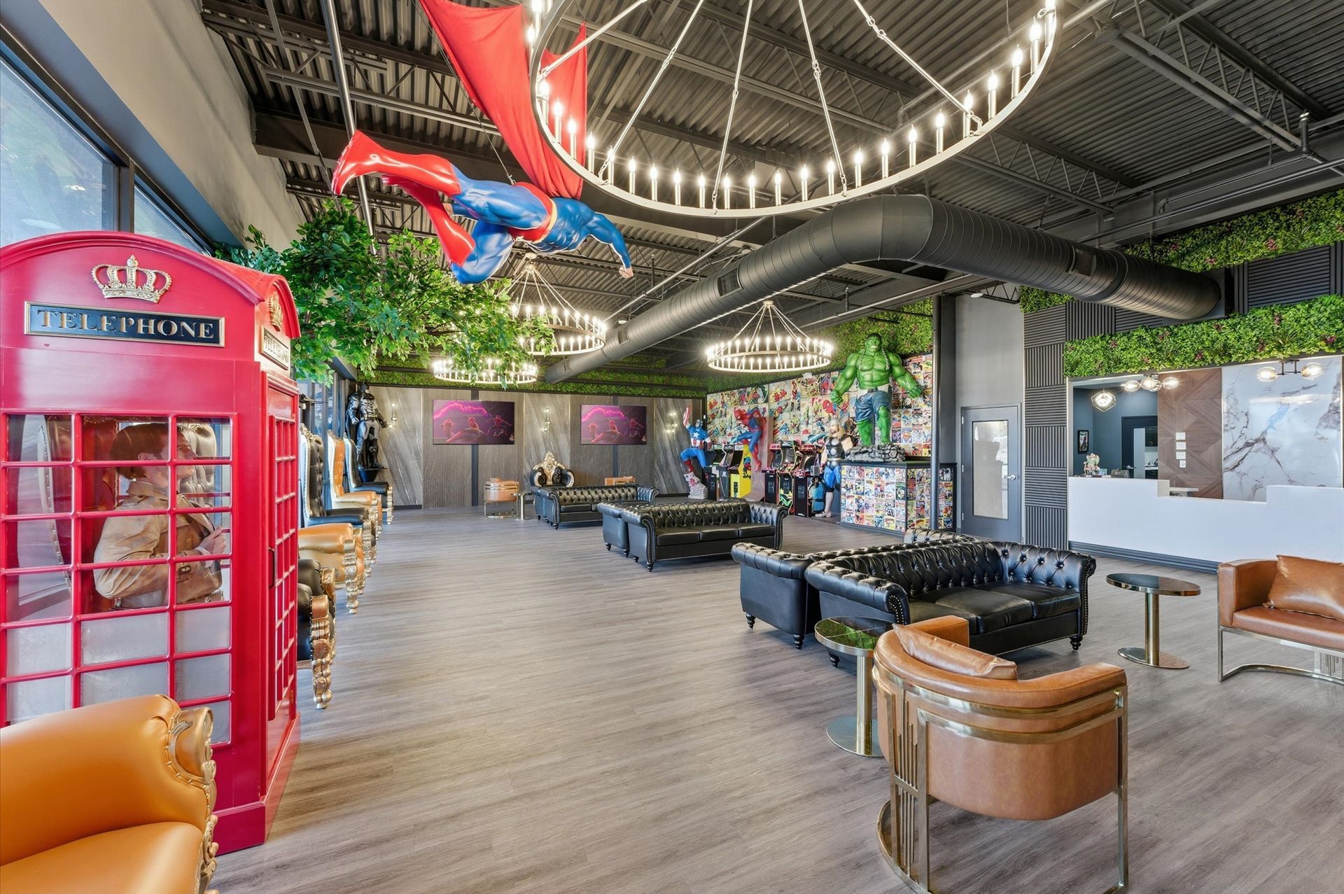 A lounge with superhero decor, a red phone booth, and leather seating.
