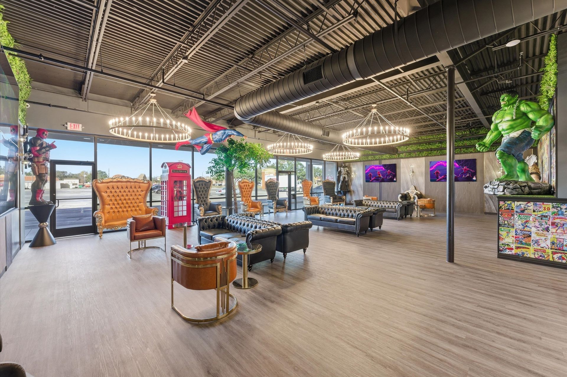 Lounge with superhero décor: Hulk statue, chandelier lights, black sofas, glass windows, and a comic-themed table. Adventure Smiles Dental and Orthodontics -Pasadena
