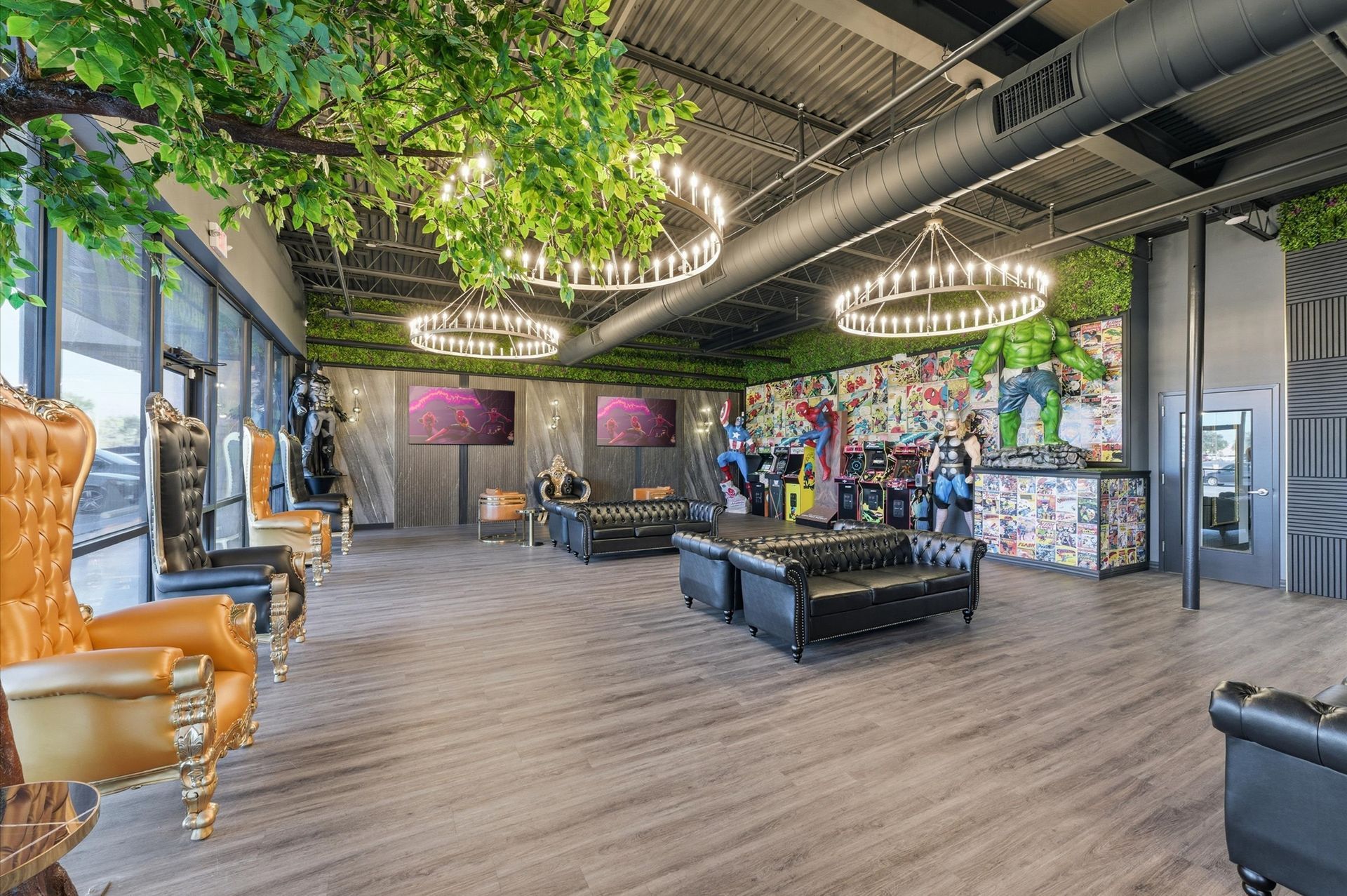 Lounge area with ornate chairs, black leather furniture, and a colorful mural. Greenery and chandeliers hang from the ceiling.  Adventure Smiles Dental and Orthodontics -Pasadena