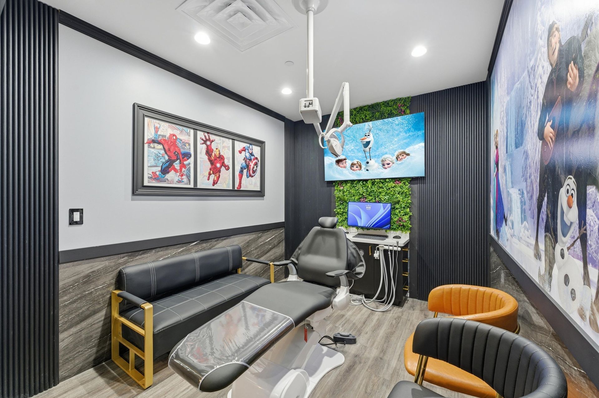 Dental exam room with superhero art, medical equipment, and Frozen movie mural.