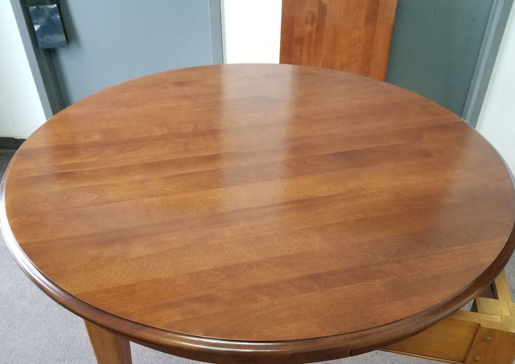 Round wooden table with a polished brown surface in a room