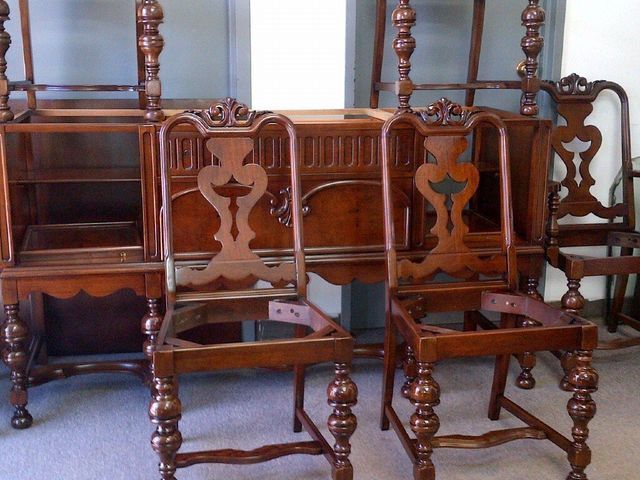 Stacked vintage wooden chairs with carved backs in a room