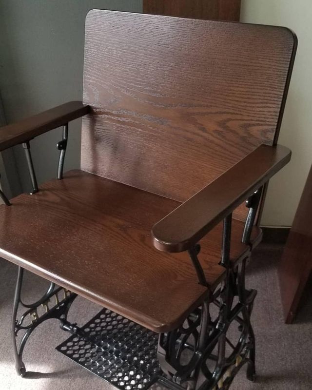 Wooden lift chair with carved metal frame and side armrests, shown indoors.
