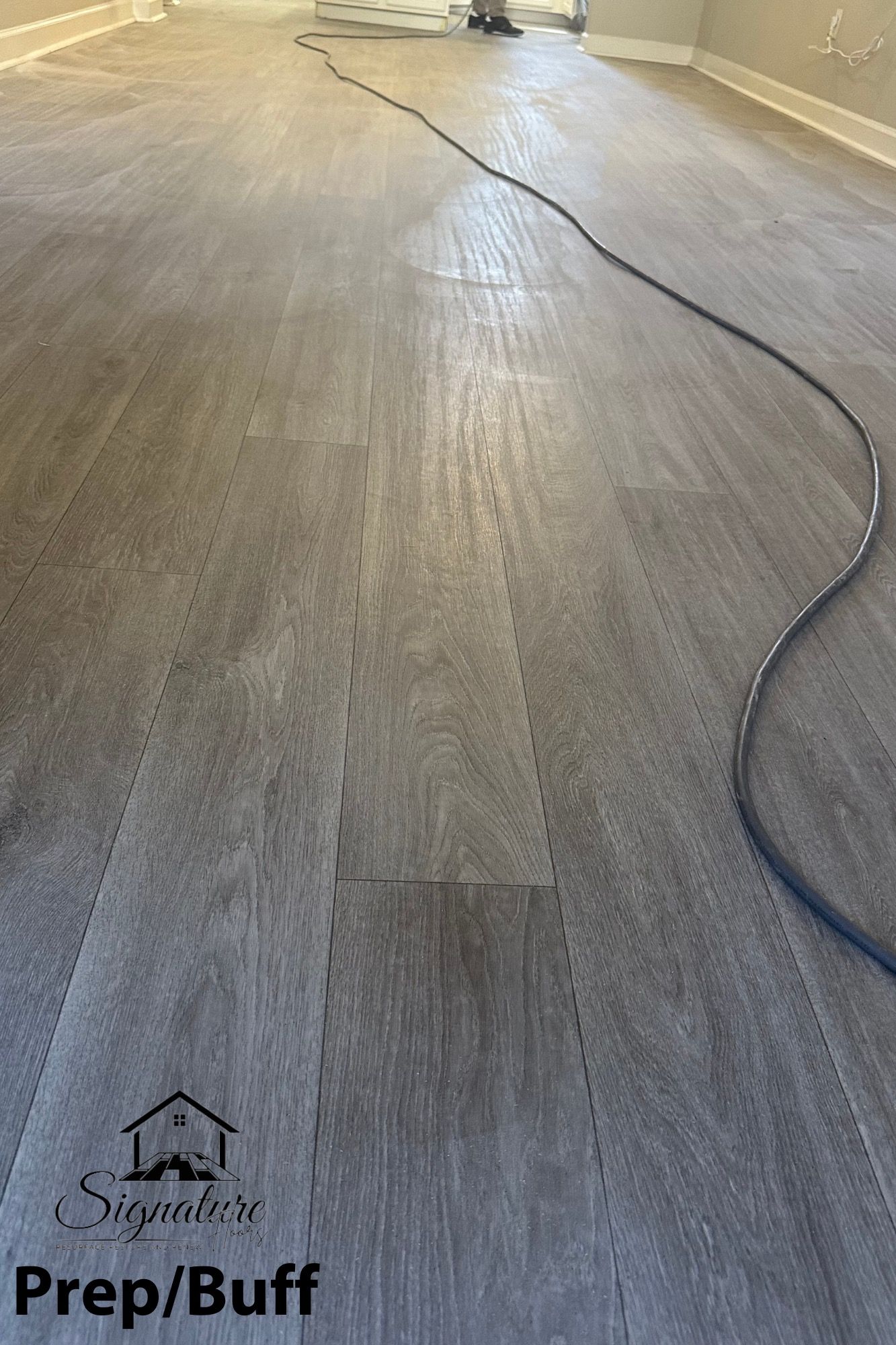 A vacuum cleaner is sitting on a wooden floor in a room.