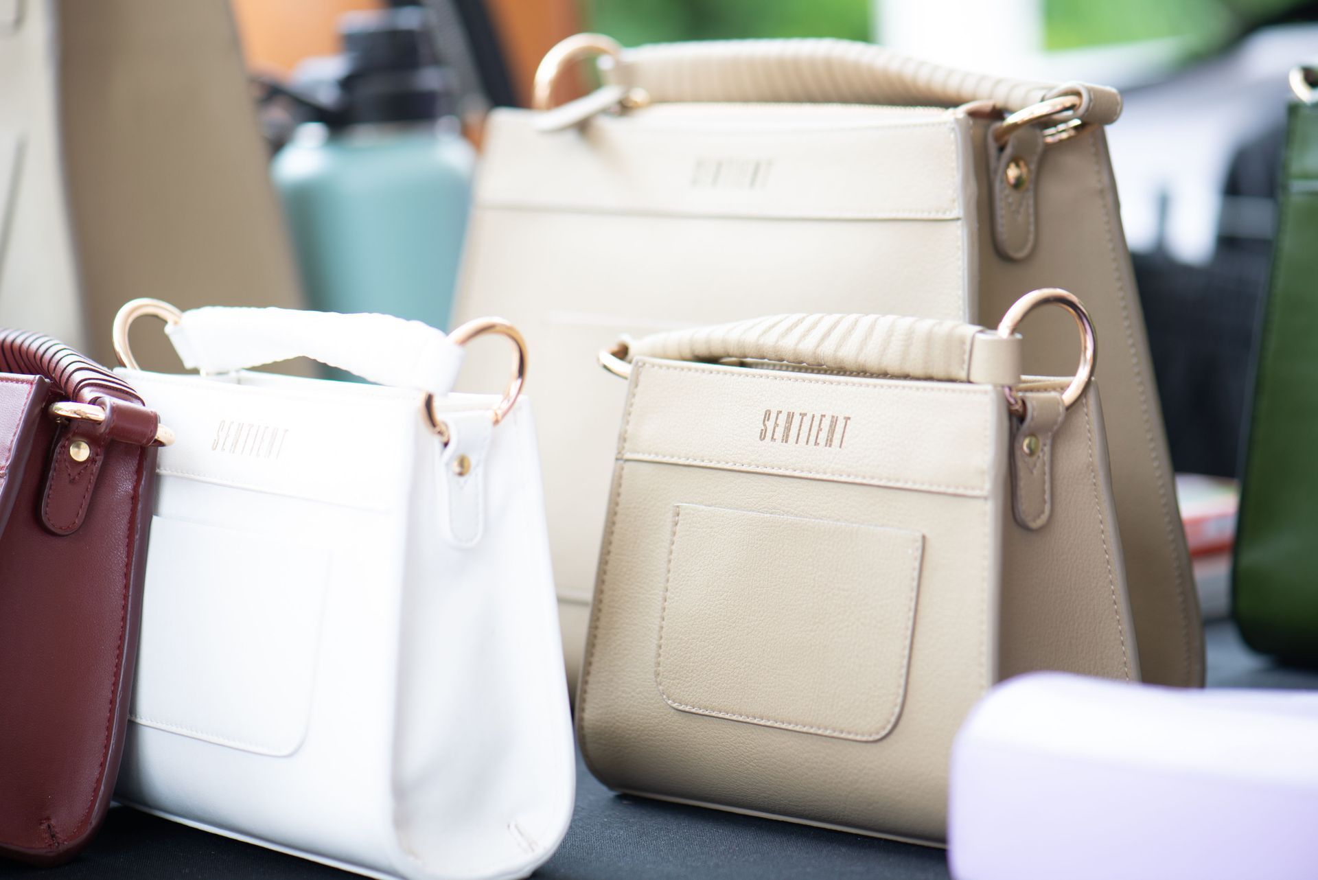 A group of handbags are sitting on a table.