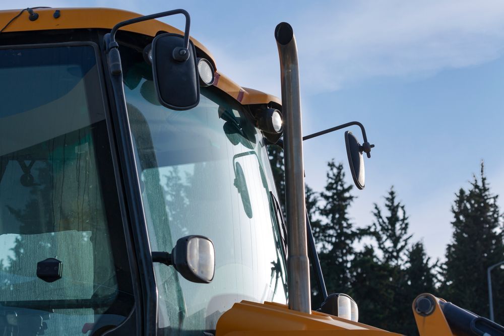 A Close Up of a Yellow Tractor With Trees in the Background — Crakka Windscreens in Diamond Beach, NSW