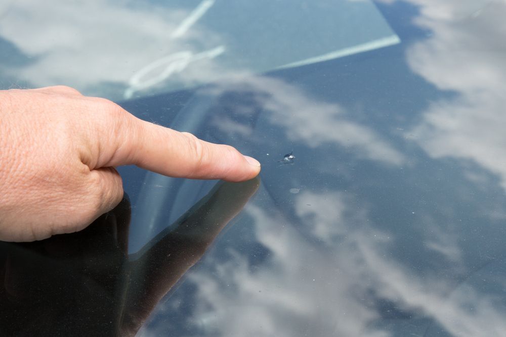 A Person is Pointing at a Chip in the Windshield — Crakka Windscreens in Diamond Beach, NSW