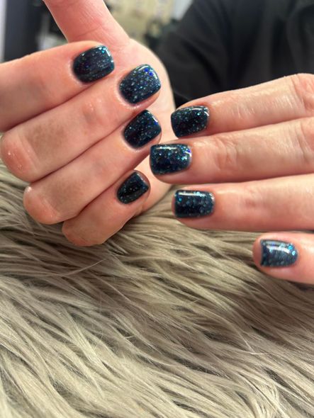 A close up of a person 's hands with blue nails.