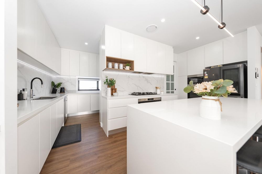 A Kitchen With White Cabinets, A Sink, A Stove And A Microwave — ASM Joinery In Fyshwick, ACT