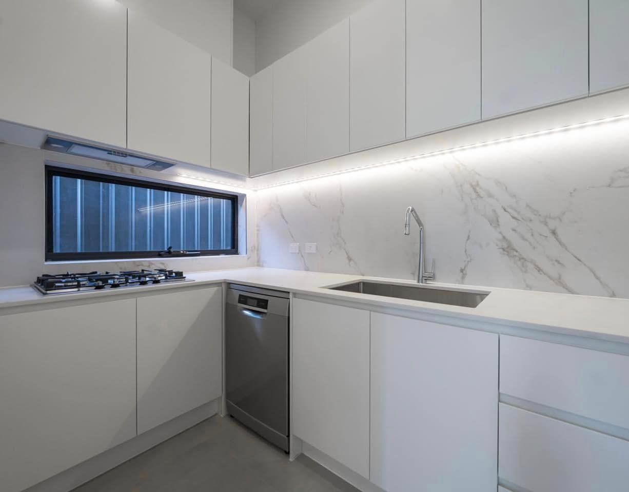 A Kitchen With White Cabinets, A Sink, A Stove And A Window — ASM Joinery In Fyshwick, ACT