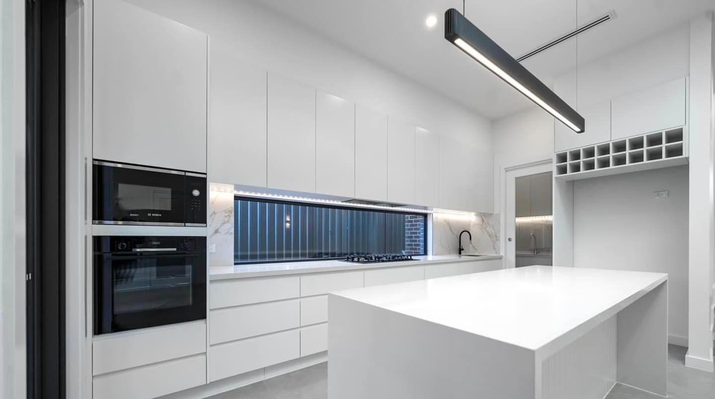 A Kitchen With White Cabinets, Black Appliances, And A Large Island — ASM Joinery In Fyshwick, ACT
