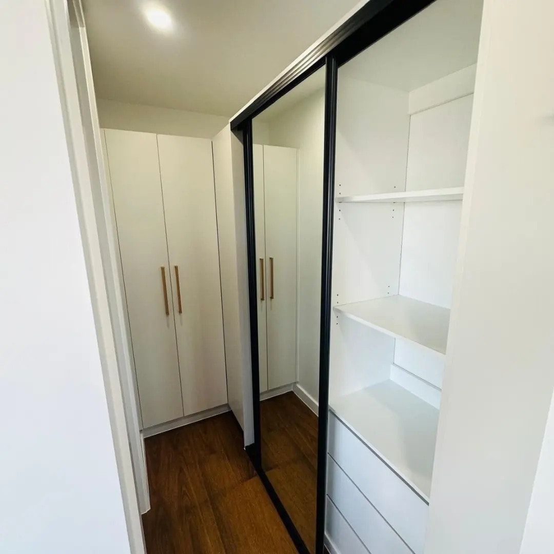 A Walk In Closet With Sliding Glass Doors And Shelves — ASM Joinery In Fyshwick, ACT