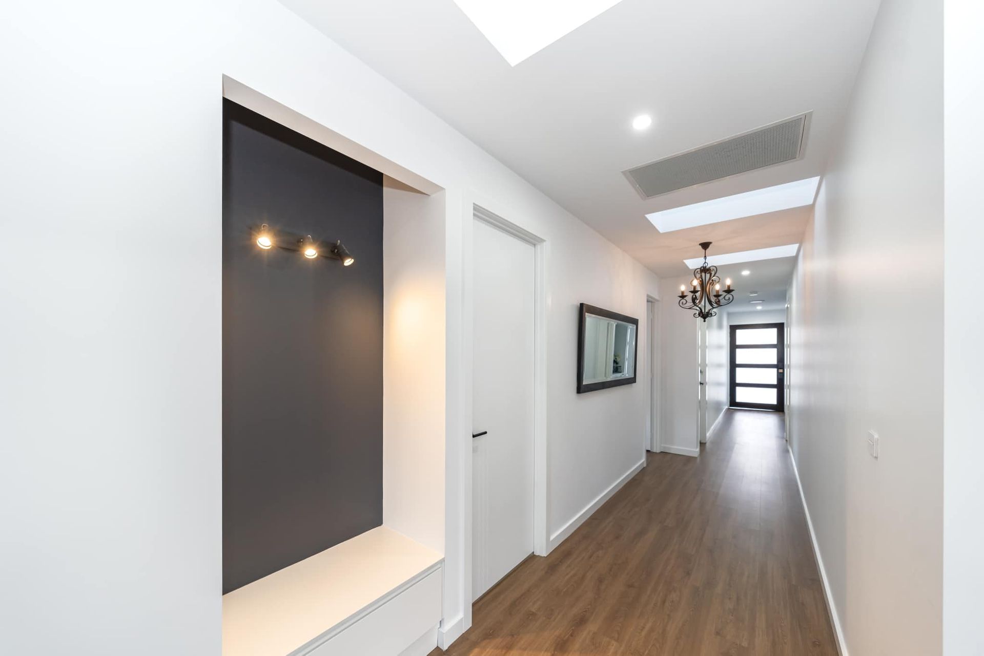 A Long Hallway With White Walls And Wooden Floors In A House — ASM Joinery In Fyshwick, ACT