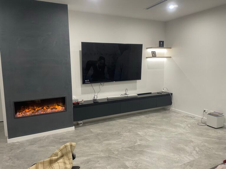 A Living Room With A Fireplace And A Flat Screen Tv On The Wall — ASM Joinery In Fyshwick, ACT