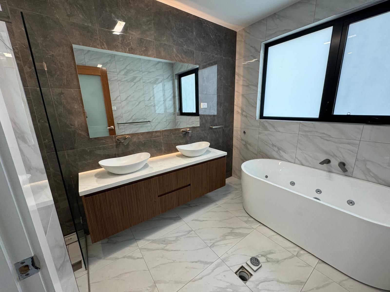 A Bathroom With A Bath A Sink And A Mirror — ASM Joinery In Fyshwick, ACT