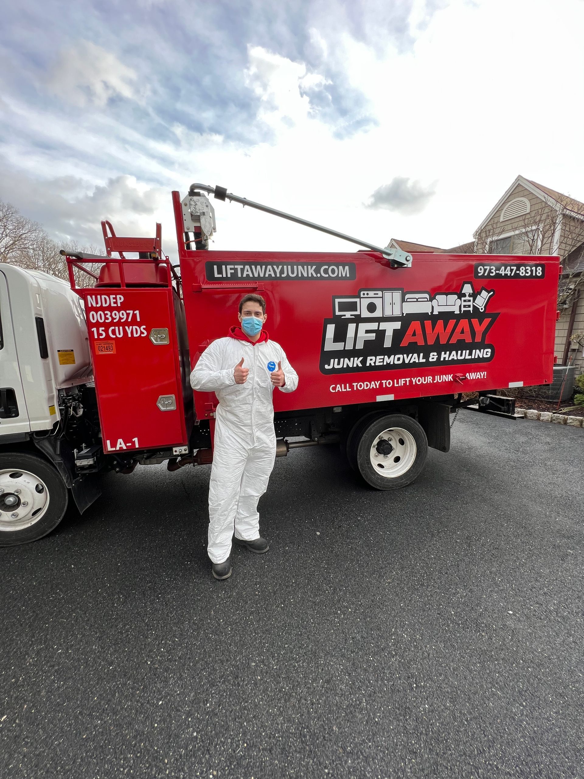 Man in white suit giving thumbs up next to a red 