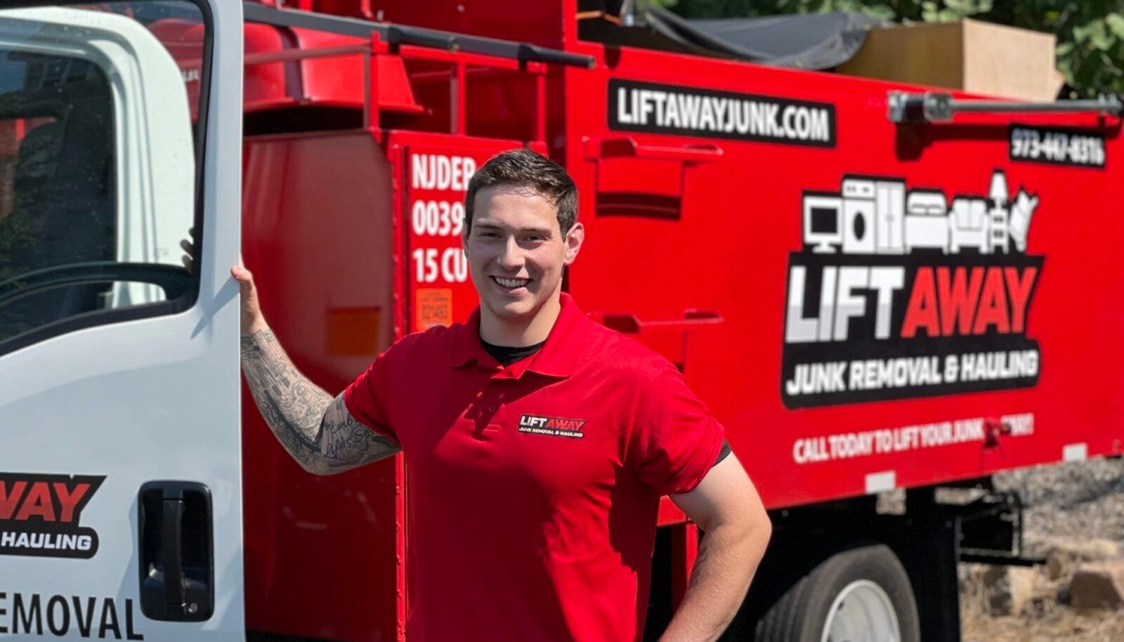 Man in red shirt stands next to a red 