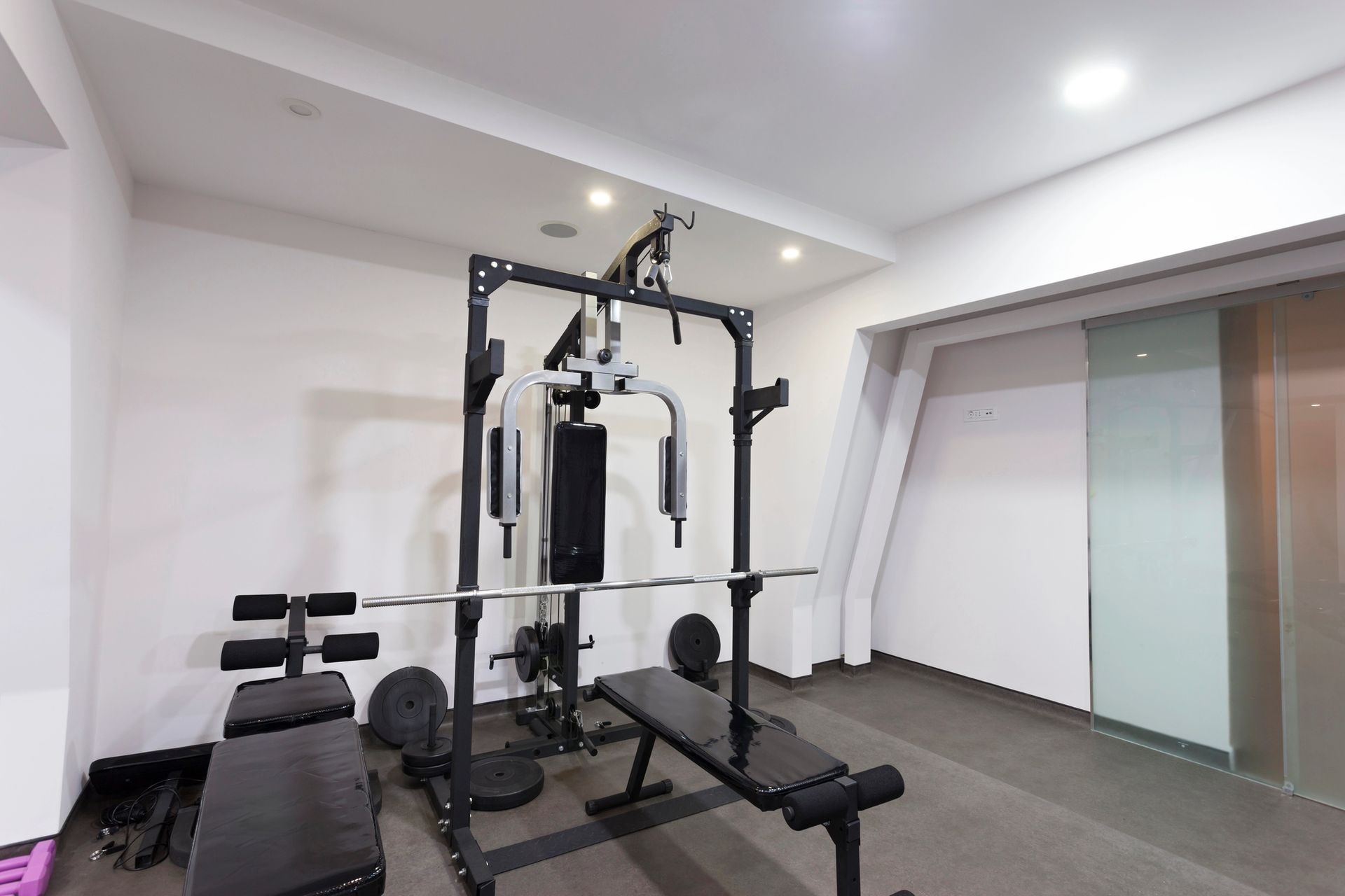 Gym with weight bench, multi-station gym equipment, and a door.