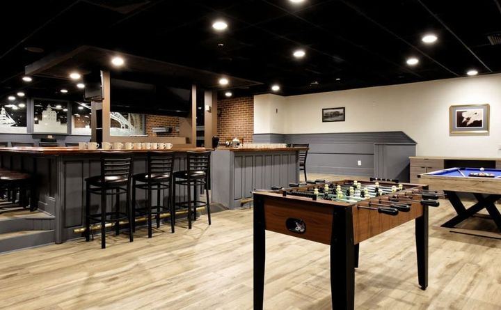 A game room with a foosball table and a pool table.