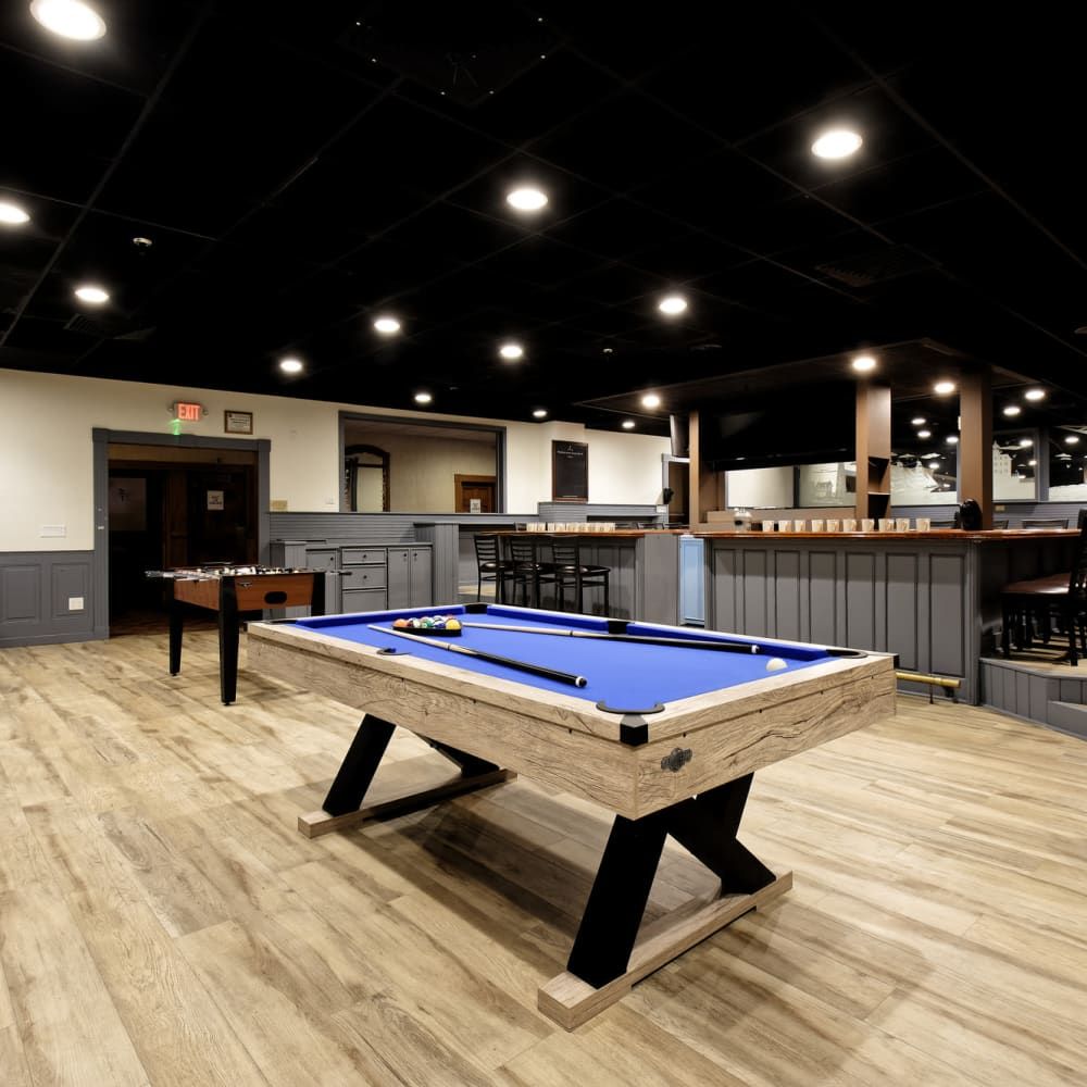 A pool table in a room with a wooden floor