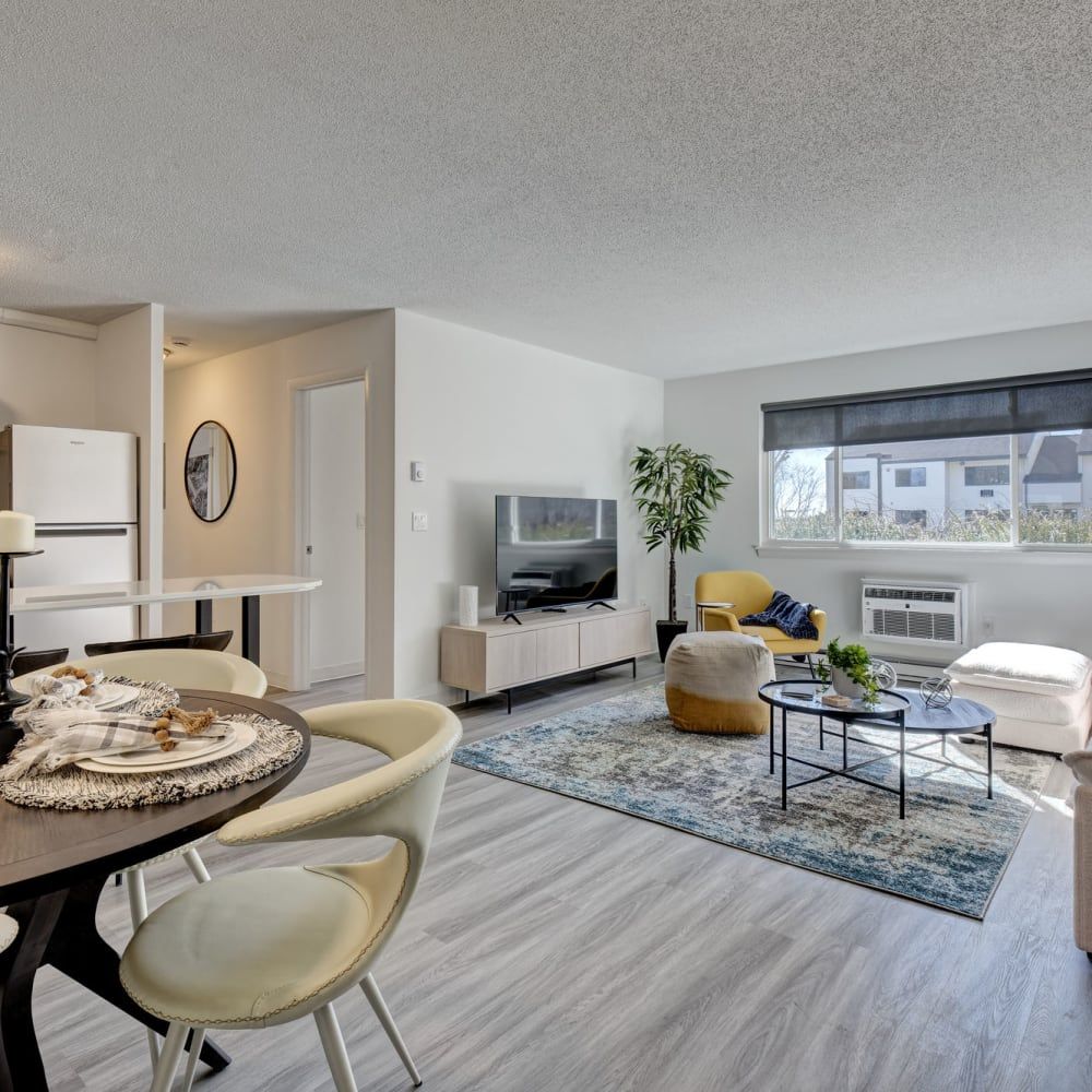 A living room with a table and chairs and a television
