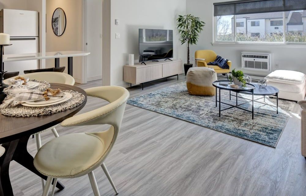 A living room with a table and chairs and a television.
