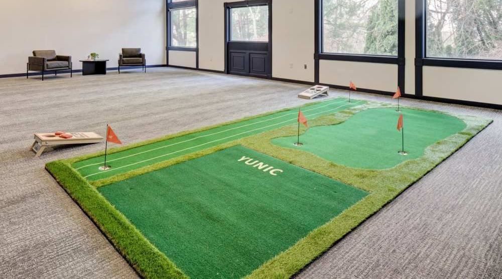 There is a putting green in the middle of the room.