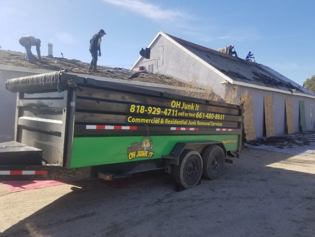 Workers on roof with trailer labeled 