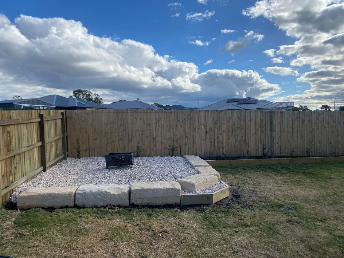A Backyard With a Wooden Fence and Gravel in It — Ape Earthmoving In Westbrook, QLD