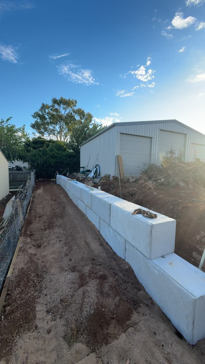 A Concrete Wall is Being Built in Front of a Garage — Ape Earthmoving In Westbrook, QLD