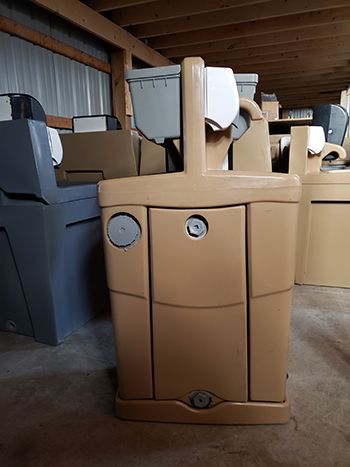 A row of toilets are sitting in a warehouse.