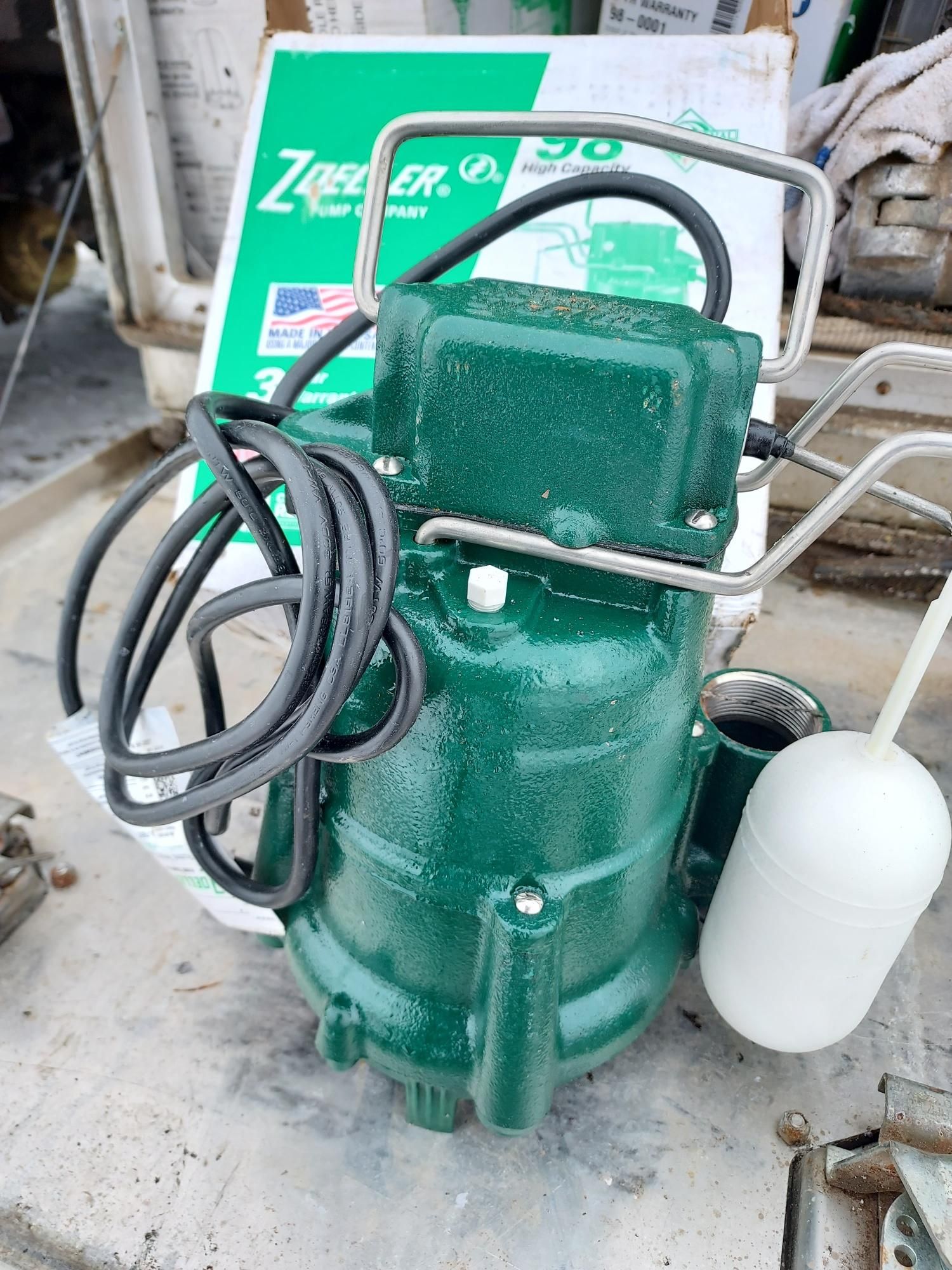 A large black septic tank is sitting in the middle of a dirt field.