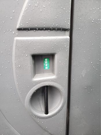 A close up of a door with a green sticker on it that says `` open ''.